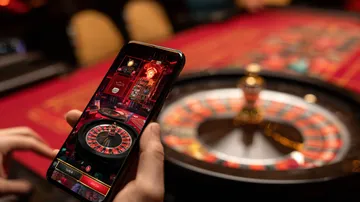 Uma mulher alegre em roupas tradicionais usando seu smartphone durante um momento festivo, mostrando como o app 63VS se encaixa facilmente no dia a dia.